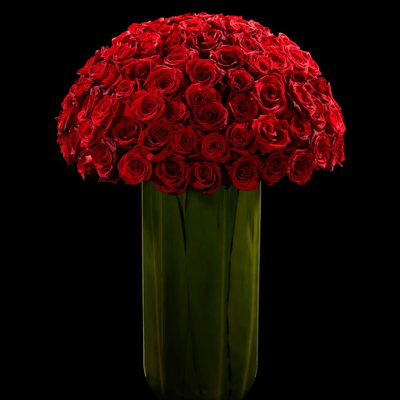Large red rose arrangement in a tall glass vase