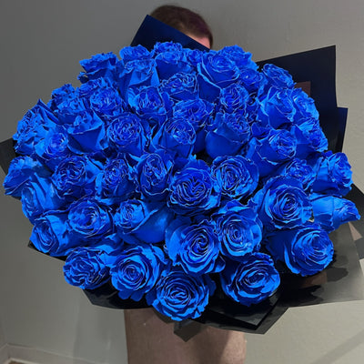 Blue rose bouquet in dark wrapping