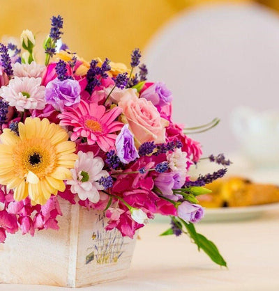 Colorful table arrangement with roses, gerberas and mixed flowers