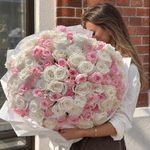 150 pale pink and white roses in a round bouquet with white wrapping